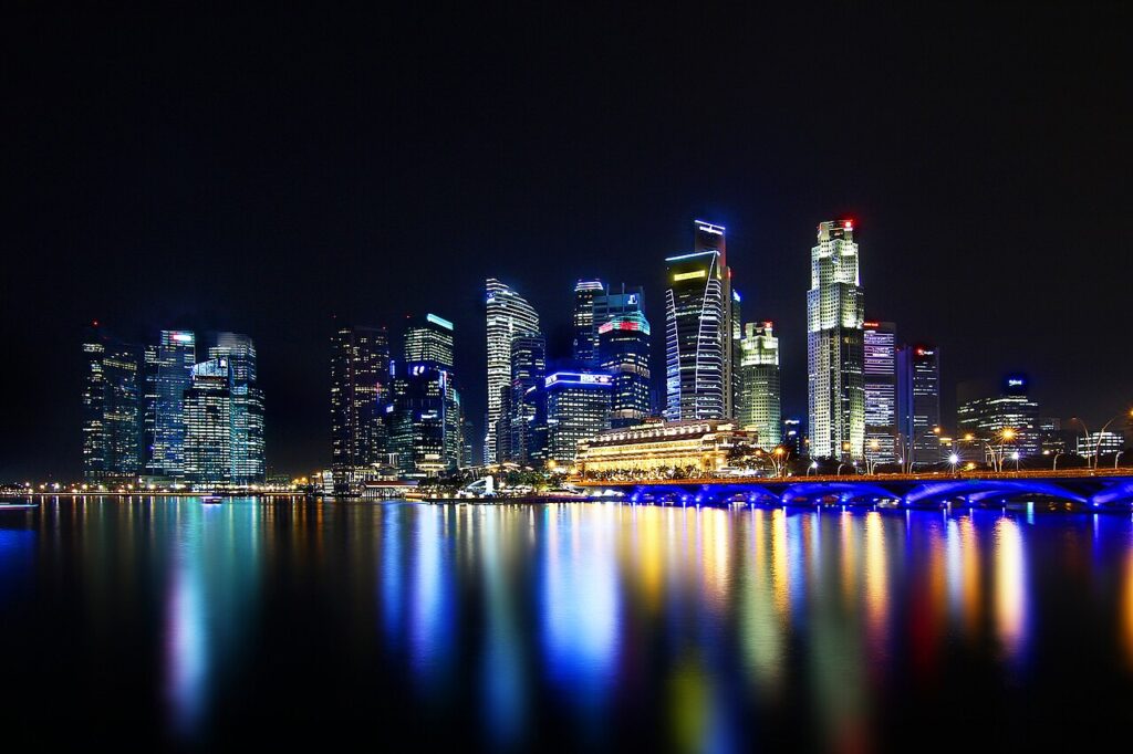 Singapore skyline illuminated at night with colourful reflections across the water